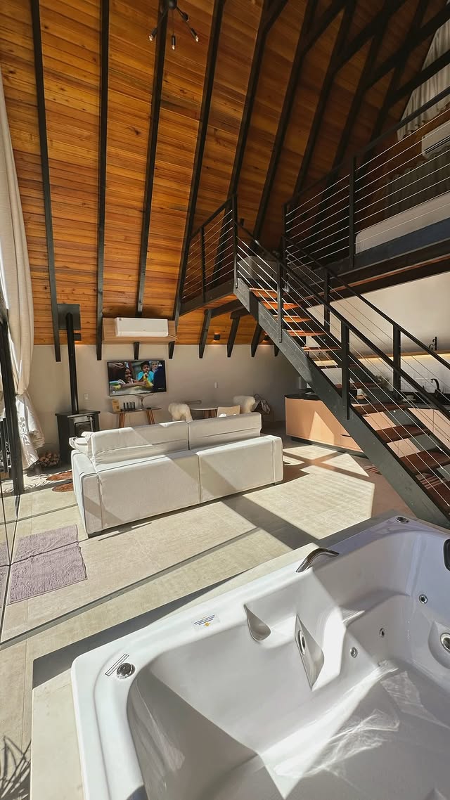 Interior do chalé com sala e escada