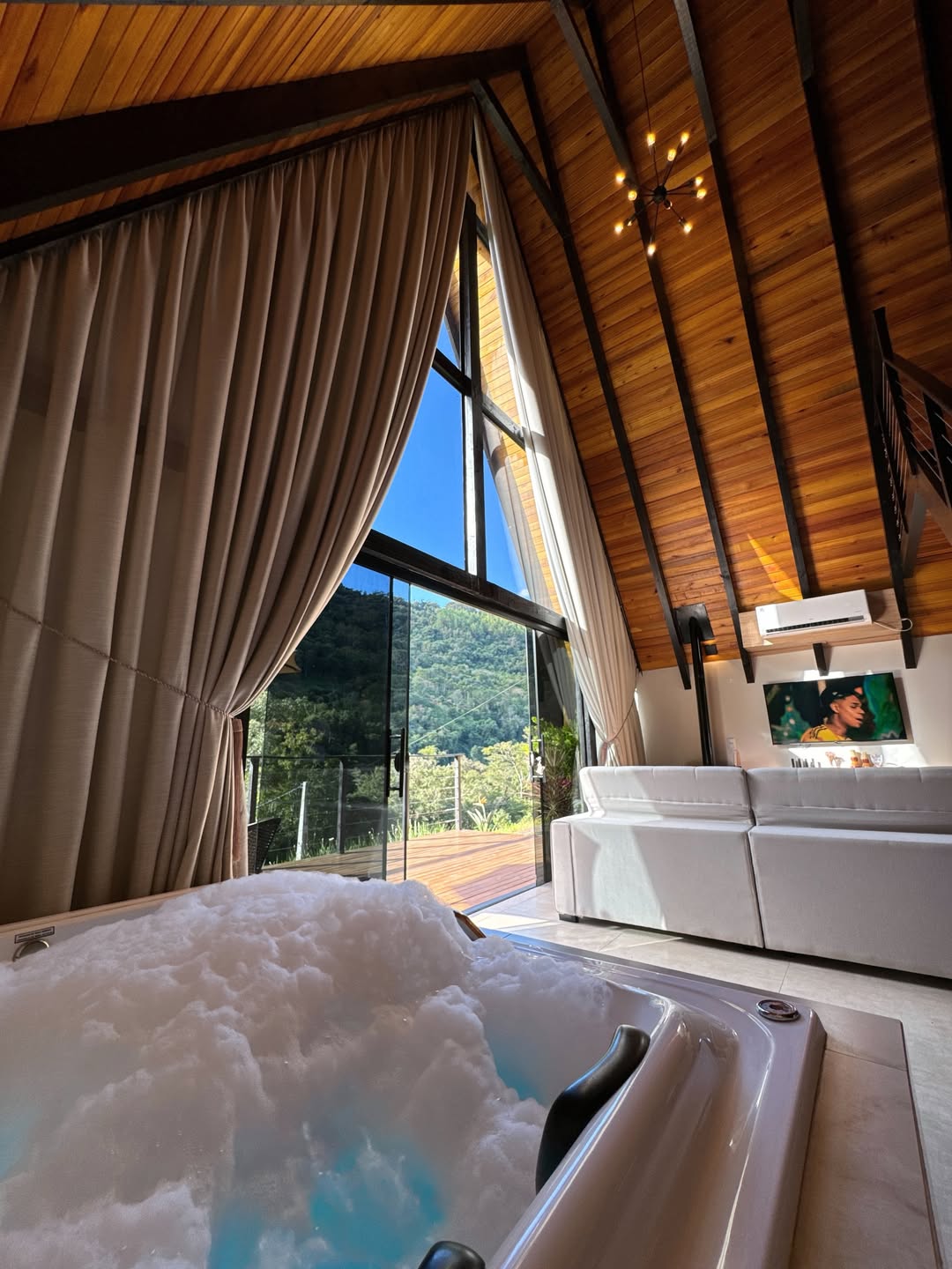 Interior do chalé com sala e escada